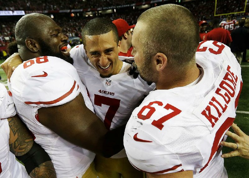 San Francisco quarterback Colin Kaepernick (center) is congratulated by teammates Leonard Davis (left) and Daniel Kilgore after the 49ers beat the Atlanta Falcons in the NFC Championship Game on Sunday at the Georgia Dome in Atlanta. The 49ers will play the Baltimore Ravens in Super Bowl XLVII on Feb. 3. 