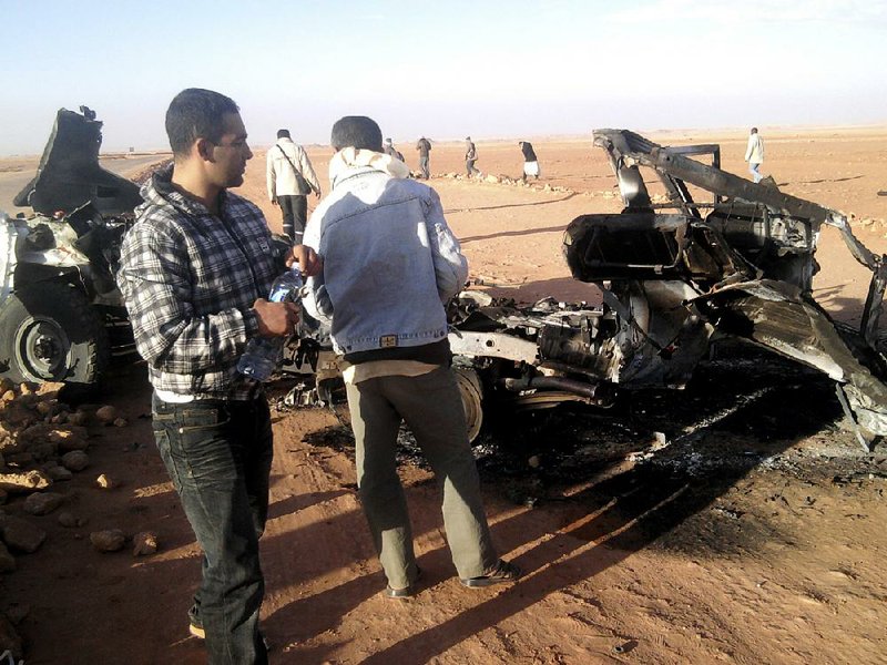 Algerians look at the wreckage of a vehicle near Ain Amenas, Algeria. Algerian bomb squads scouring a gas plant where Islamist militants took dozens of foreign workers hostage found “numerous” bodies Sunday. 
