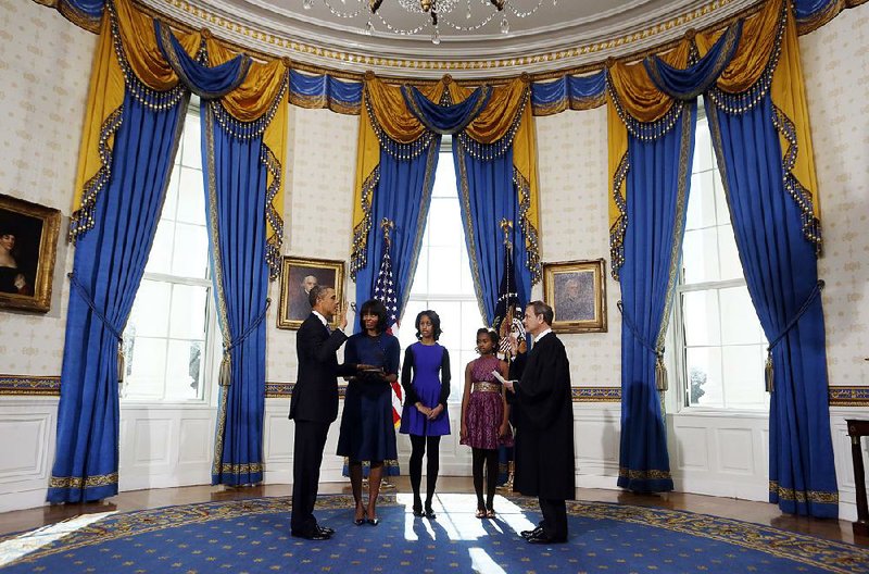 President Barack Obama is officially sworn in by Chief Justice John Roberts in the Blue Room of the White House on Sunday. Next to Obama are first lady Michelle Obama, holding the Robinson family Bible, and daughters Malia and Sasha.