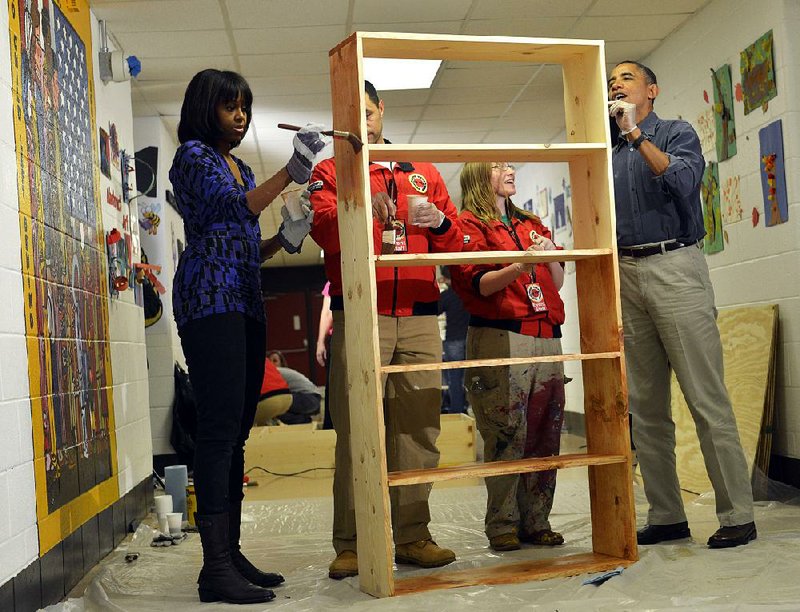 First lady Michelle Obama and President Barack Obama join City Year workers Saturday in staining a bookcase at Burrville Elementary School in Washington for the National Day of Service. 