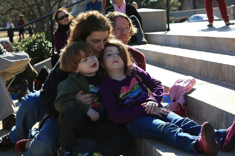 Russell Britt, his wife, Allison, and their children Cyrus, 5, and Amelia, 6, all of Hot Springs, listen to speakers Saturday at the Rally for Reproductive Justice on the steps of the state Capitol in Little Rock. 