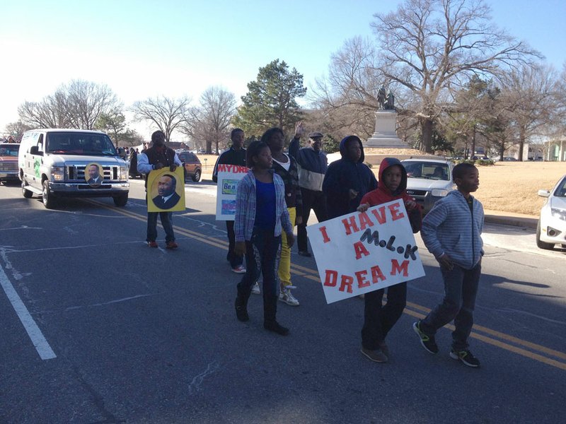 Participants march in the MLK Day parade outside the Capitol on Monday.