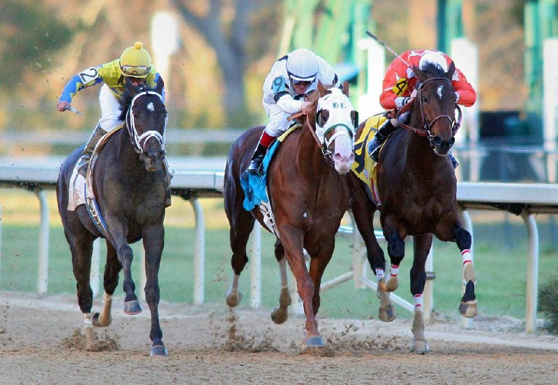 Jockey Jon Court, aboard Will Take Charge (center), crosses the finish line ahead of jockey Paco Lopez, aboard Always in a Tiz (left), and Cliff Berry, aboard Texas Bling, during the Smarty Jones Stakes on Monday afternoon at Oaklawn Park in Hot Springs. 