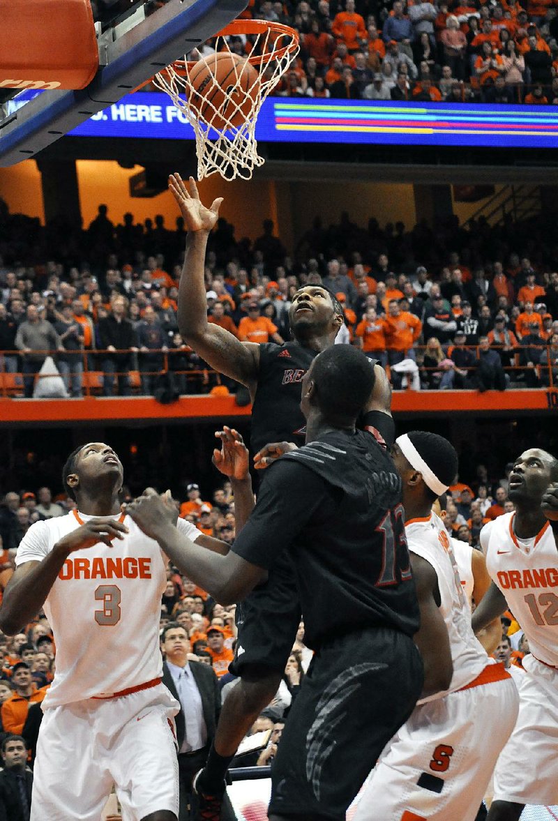 Cincinnati forward Titus Rubles (center) watches the ball go in for what proved to be the game-winner with 19.4 seconds left in Monday’s game in Syracuse, N.Y. Syracuse forward C.J. Fair (lower right wearing a headband) was credited with the tip-in, even though he’s not entirely sure he did it. 
