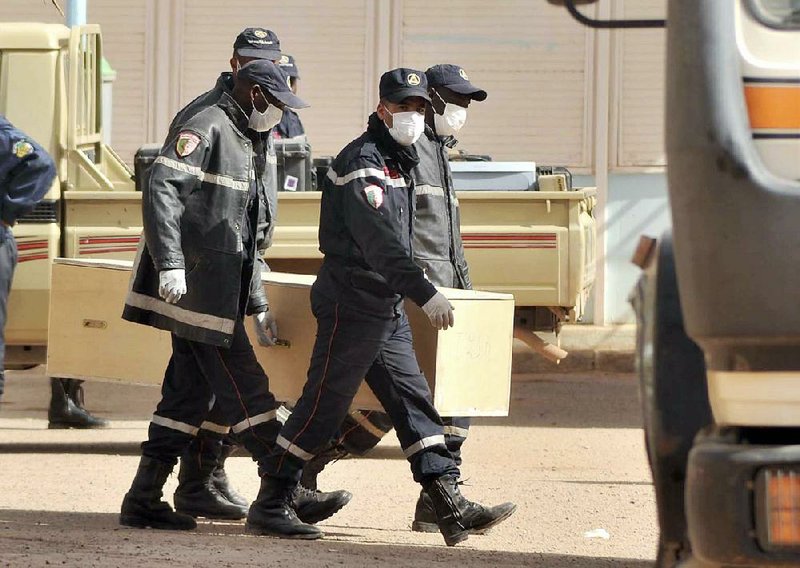 Algerian firemen carry a coffin Monday into the morgue in Ain Amenas, Algeria. The coffin contains the body of a person killed during the hostage situation in a gas plant. 