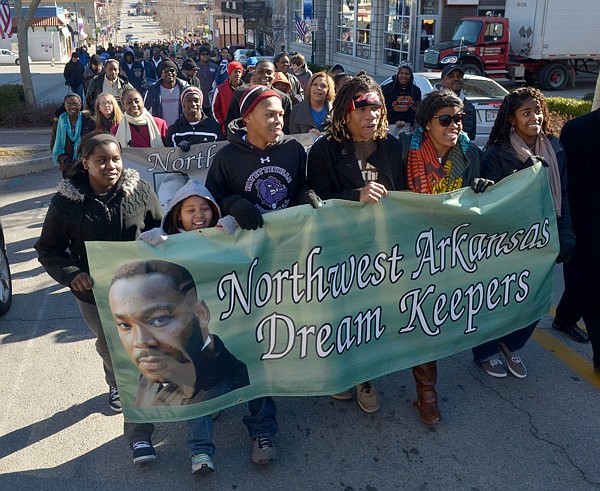 Raven Hampton, from left, 13, Makena Hampton, 9, Jarrod Howard, 15, Trey Smith, 17, Jervae Franklin, 19, and Sandra Walton, 17, all from Fayetteville, carry a banner as they lead the annual Martin Luther King Day march up Dickson Street on their way to the University of Arkansas in Fayetteville on Monday morning. More than a thousand people took part in the event. For additional coverage, see pages 4A and 1B of the Arkansas Democrat-Gazette and visit nwaonline.com/videos for related video. 