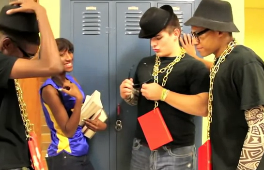 A screen grab from a North Little Rock High School video promoting literacy shows students wearing books on gold chains around their necks.