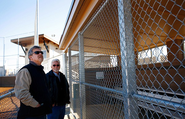 Steve Milligan, left, and Randy Ward, both with Modern Fence & Supply in Springdale, look over one of the completed dugouts Monday at the Rogers Regional Sports Park. Officials held a ribbon-cutting ceremony for the park, which will host its first tournament this weekend. 