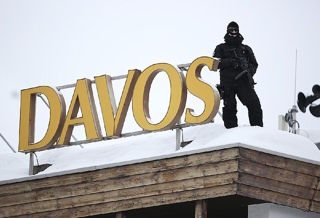 An armed police officer stands on the snow-covered rooftop of the Hotel Davos and looks out over the Congress Center, the venue for the World Economic Forum (WEF) in Davos, Switzerland, on Tuesday, Jan. 22, 2013. World leaders, Influential executives, bankers and policy makers arrive in the Swiss Alps for the 43rd annual meeting of the World Economic Forum in Davos, the five day event runs from Jan. 23-27. Photographer: Jason Alden/Bloomberg
