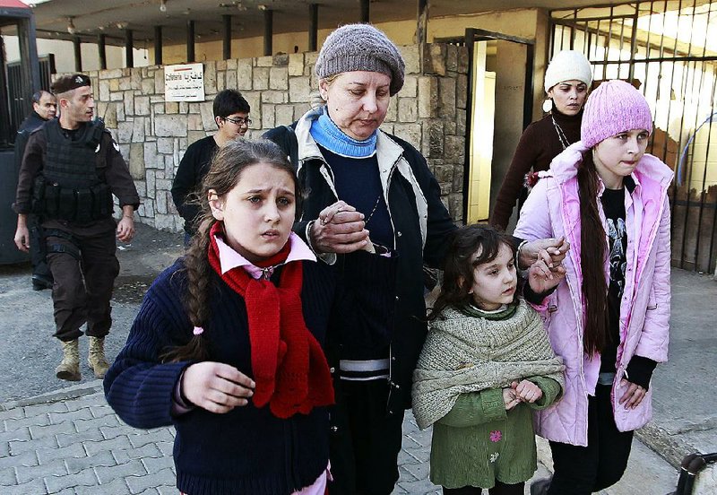 Russian family walk together shortly after crossing the border from Syria into Lebanon at the Masnaa border crossing in eastern Lebanon, Tuesday, Jan. 22, 2013. Some 80 Russian citizens crossed into Lebanon as Moscow began evacuating some of the tens of thousands of Russians who live in Syria. (AP Photo/Bilal Hussein)