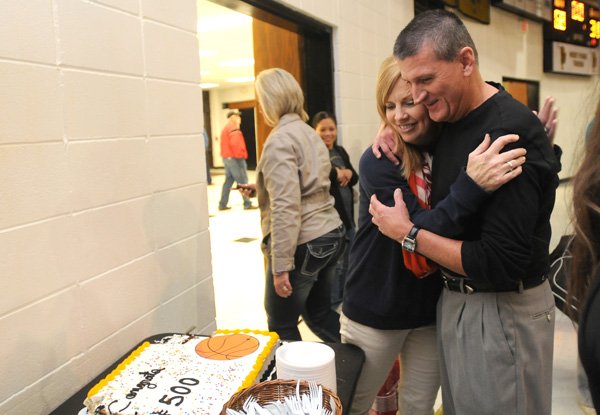 David Ferrell, right, West Fork boys coach, hugs his wife, Kelly Ferrell, while celebrating his 500th win as a high school coach Tuesday at West Fork. The Tigers defeated Green Forest, 68-31. 