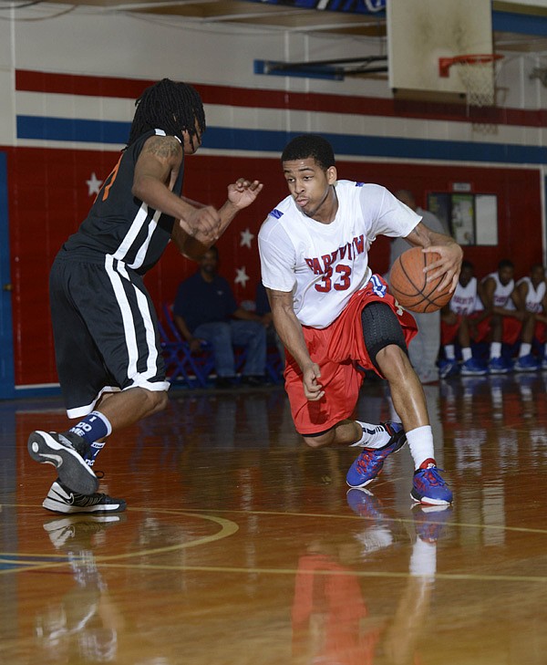 Little Rock Parkview’s Anton Beard (33) tries to dribble around Little Rock Hall defender Javon Perry during the Patriots’ 57-52 loss Tuesday at Charles Ripley Arena in Little Rock. 