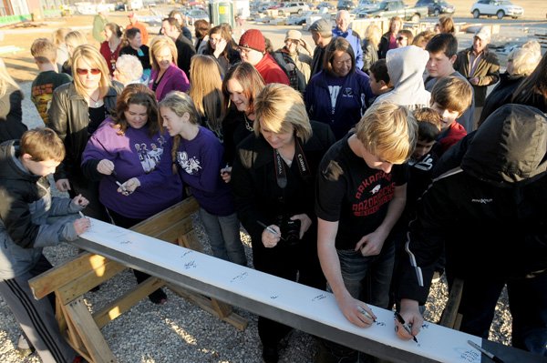 Parents, students and employees of the Elkins School District sign a steel beam Tuesday at a ceremony in front of the district’s new high school in Elkins. Once completed it will replace the old building. 