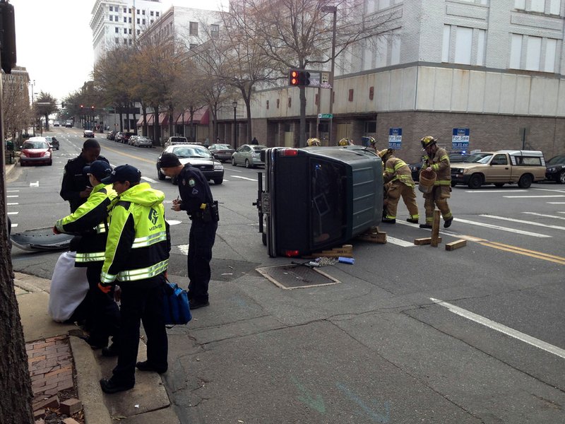 Authorities work the scene Wednesday, Jan. 23, 2013, after a car overturned at Capitol and Center streets in downtown Little Rock.