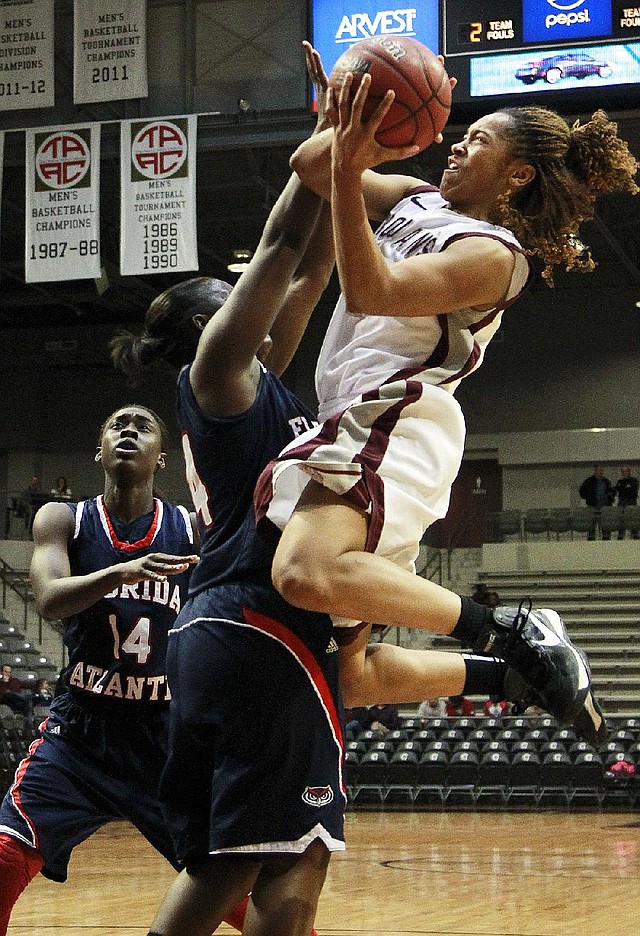 UALR junior guard Taylor Ford (right) shoots over Florida Atlantic defenders Latavia Dempsey (left) and Shanequa Schrouder during Wednesday’s game at the Jack Stephens Center in Little Rock. Ford scored 16 points in the Trojans’ 77-45 victory. 