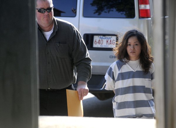 Detective Tom Boyle, left, with the Bentonville Police Department, escorts Huong Thi Truong, 28, of Bentonville, to a bond hearing Aug. 12, 2011, at the Benton County Courthouse. Arkansas State Hospital officials say Truong lacks fitness to stand trial, and Circuit Judge Robin Green ordered the hospital to petition for involuntary committment. 