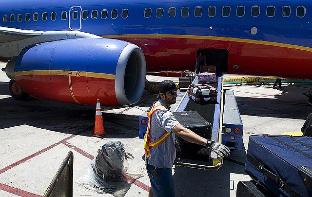 A ground crew worker loads a Southwest Airlines Co. plane in San Diego last spring. The airline said Thursday that its average fare climbed almost $8 in the fourth-quarter compared with a year ago. 