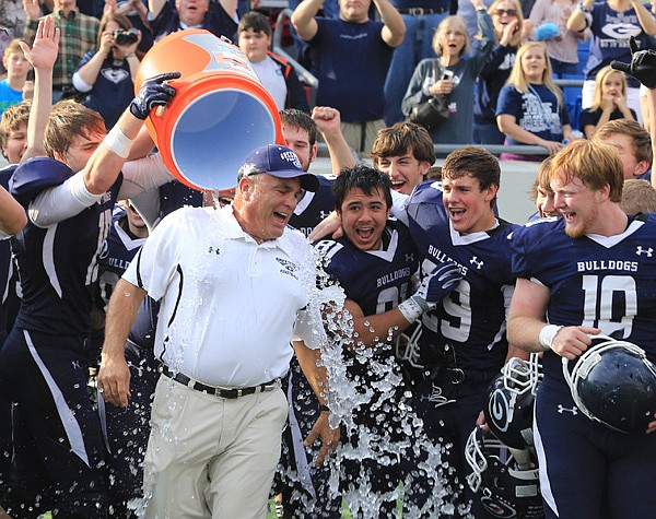 
Rick Jones, Greenwood coach, gets drenched in ice water by his players after winning the 6A state championship football game.