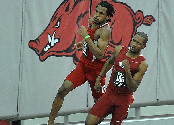 NWA Media/MICHAEL WOODS --01/25/2013-- Arkansas runner Akheem Gauntlett (front) and Nebraska runner Dexter McKenzie round the last turn in the men's 200m run during Friday night's action in the Razorback Invitational at the Randal Tyson Track Center in Fayetteville.