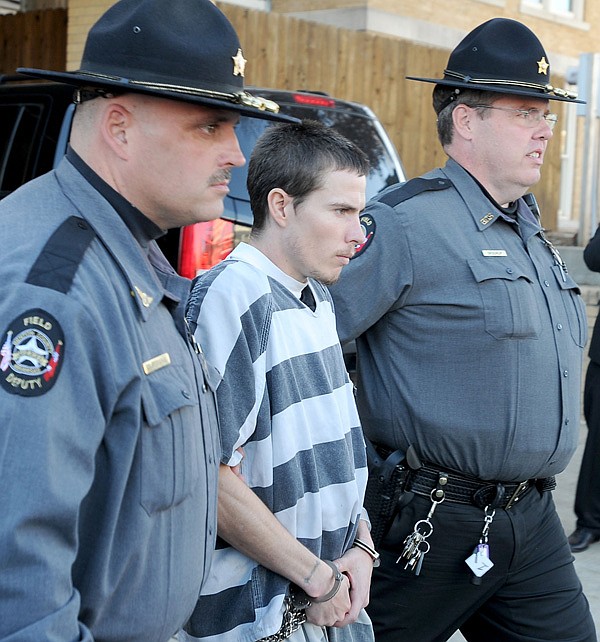 Zachary Holly, center, is escorted to a Benton County Sheriff’s Office patrol car Nov. 28 after an bond hearing at the Benton County Courthouse in Bentonville. 