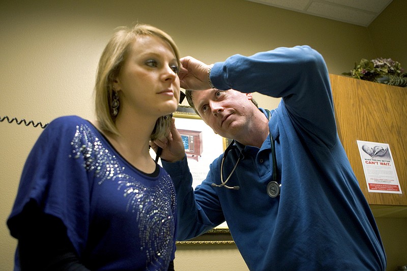 Dr. Tyler Nelson looks inside Taylor Parsons’ ear during her visit with the doctor at the Bryant Medical Clinic.