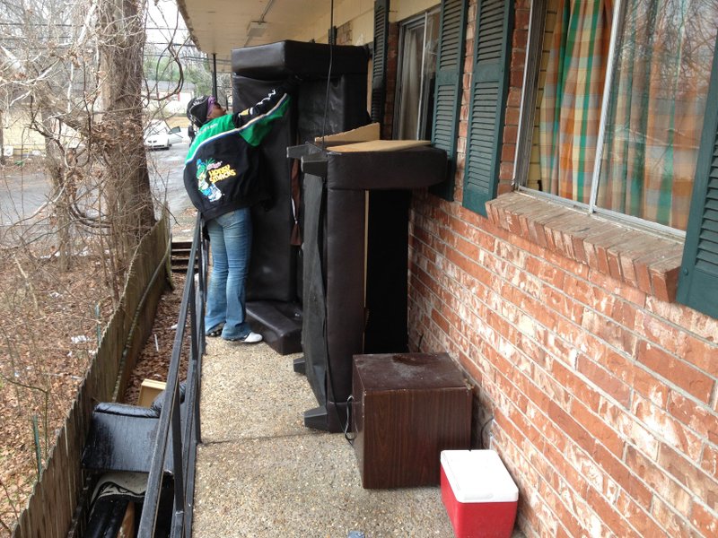 Shonda Blackwell moves furniture from her unit at Stonecrest Apartments Friday morning.