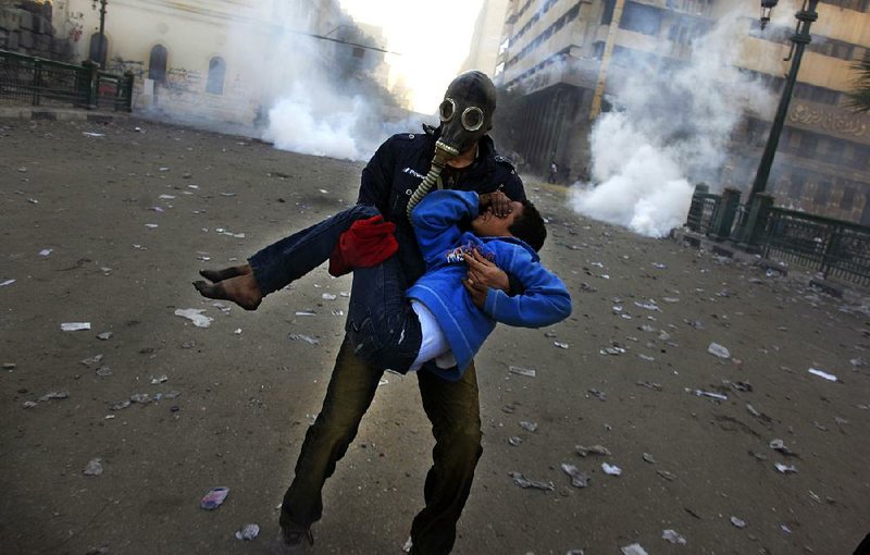 An Egyptian protester evacuates an injured boy during clashes Friday near Tahrir Square in Cairo. Violence broke out across Egypt as protesters marked the two-year anniversary of the country’s revolution.


