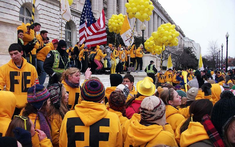 Dressed in yellow sweatshirts displaying the word “Life,” high school students from Chicago gather on the steps of a Senate office building and shout encouragement to the thousands of anti-abortion protesters who marched past the Capitol on Friday and gathered on the steps of the Supreme Court. 
