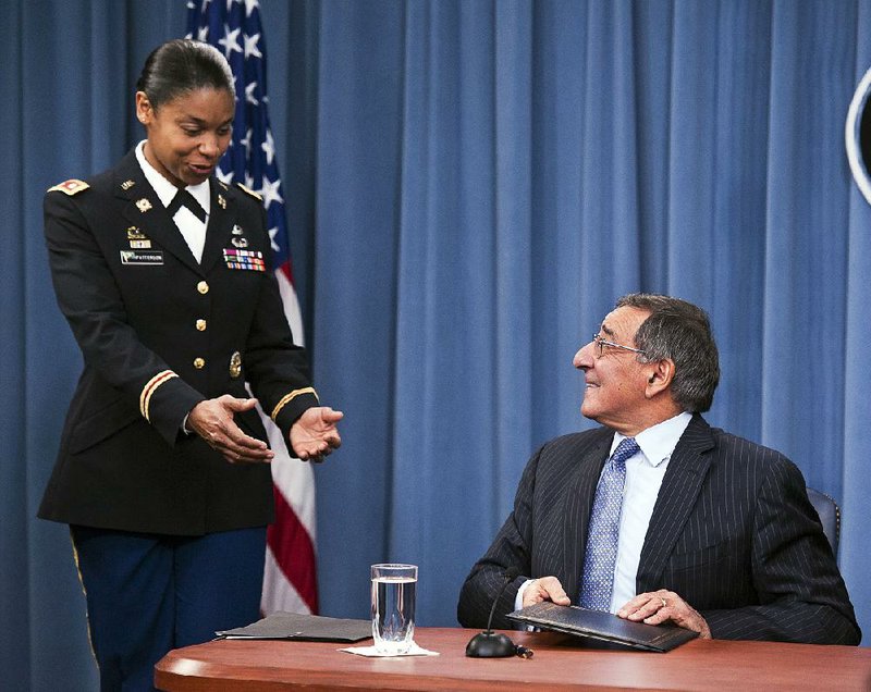 Army Lt. Col. Tamatha Patterson of Huntingdon, Tenn., waits Thursday at the Pentagon for Defense Secretary Leon Panetta to hand her the memorandum he had just signed that ends the 1994 ban on women serving in combat. 