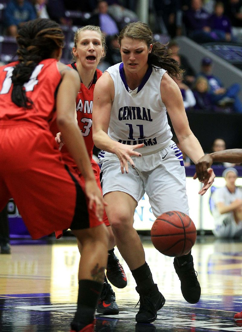 Central Arkansas forward Megan Herbert (right) loses the ball as Lamar’s Carenn Baylor (left) defends Saturday in Conway. 