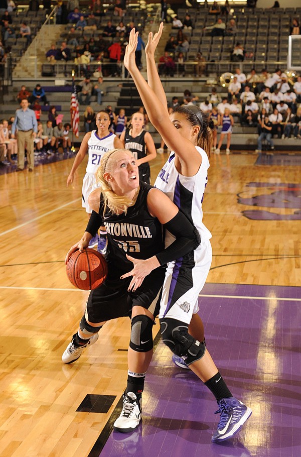 Julia Garrard of Bentonville attempts to score around Fayetteville’s Vanessa Matlock on Friday in Fayetteville. 