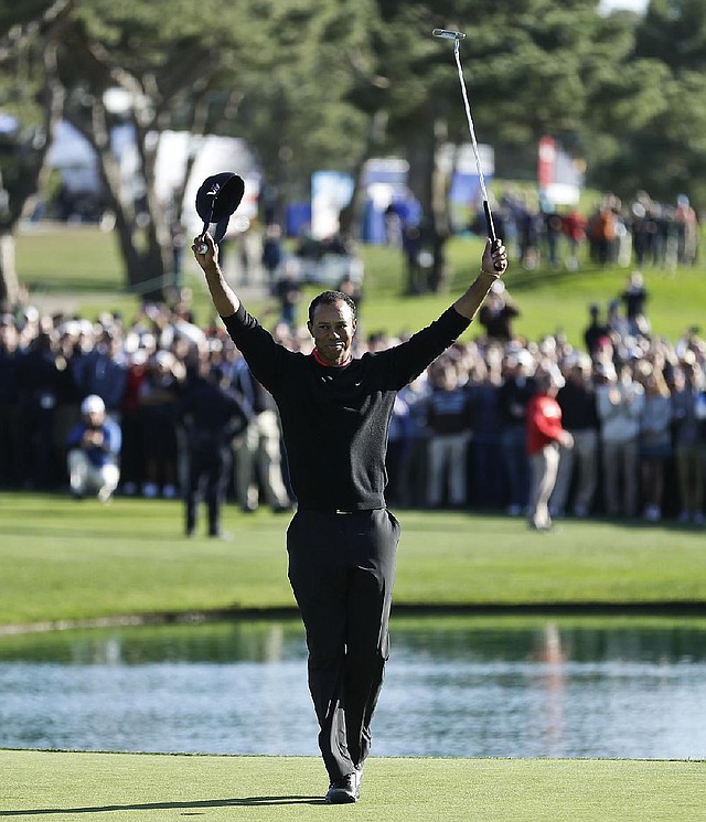 Tiger Woods celebrates after his victory in the Farmers Insurance Open on Monday in San Diego. Woods closed with a 72 and finished a four-shot victory. It was Woods’ 75th career victory, seven short of Sam Snead’s record of 82.