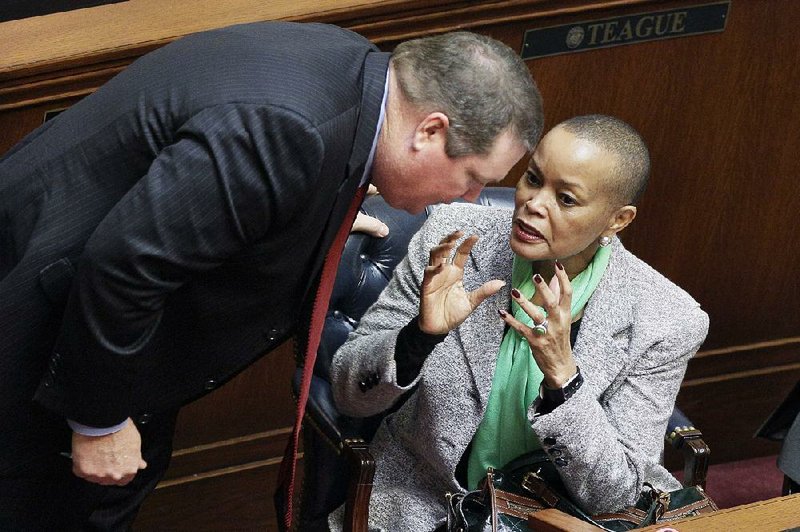 Sen. Joyce Elliott, D-Little Rock, talks with Sen. Bryan King, R-Green Forest, in the Arkansas Capitol’s Senate chamber after King’s bill to allow concealed handguns in churches passed Monday. Elliott spoke against the proposal. 