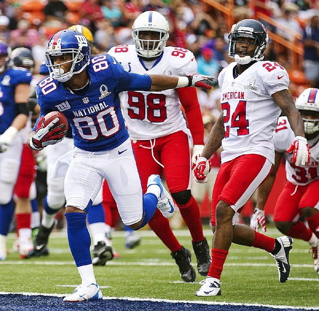 NFC wide receiver Victor Cruz (80) of the New York Giants breaks away from AFC linebacker Robert Mathis (98) of the Indianapolis Colts and AFC Houston Texans cornerback Johnathan Joseph (24) to score a touchdown during the second quarter of Sunday’s Pro Bowl in Honolulu. Cruz set a Pro Bowl record with 10 catches as the NFC cruised to a 62-35 victory. 