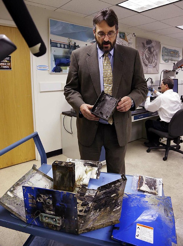 Joseph Kolly of the National Transportation Safety Board holds a burned battery case from the Japan Airlines Boeing 787 Dreamliner. The battery shows evidence of short-circuiting. 