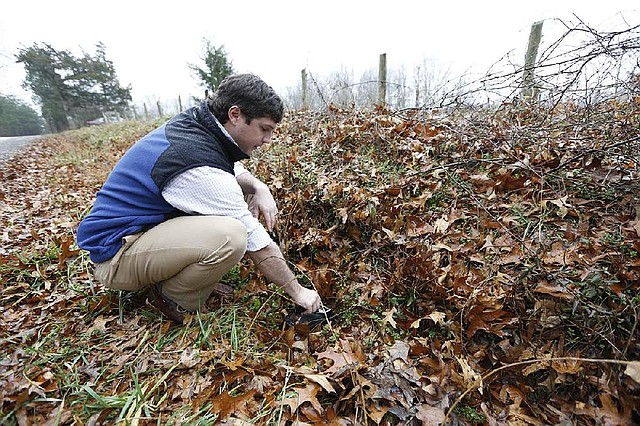 Virginia Uranium Inc. project manager Patrick Wales operates a Geiger counter in a hole next to a road at the south field of a uranium deposit on the Cole Hill farm in Chatham, Va. Uranium mining is off-limits in the state. 