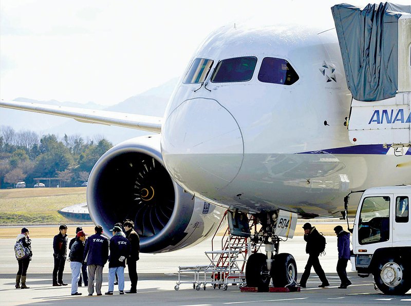 Officials inspect an All Nippon Airways Boeing 787 on Jan. 18. The plane made an emergency landing at Takamatsu airport in western Japan after a lithium-ion battery in the plane caught fire. 