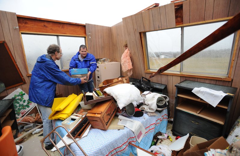 Volunteers, neighbors and emergency personnel work Tuesday, Jan. 29, 2013, to recover personal items from Orvetta Cox's home on Hummingbird Road in Fayetteville after the house was damaged by storms.