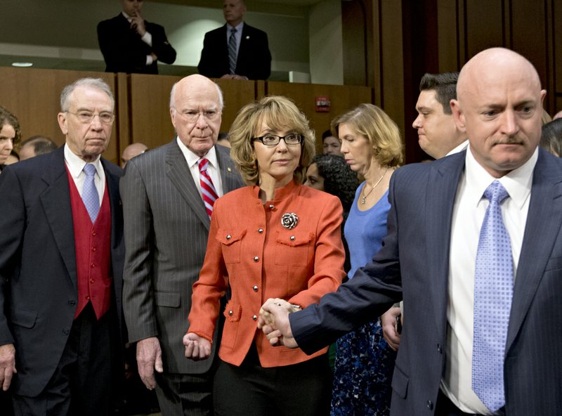 Former Arizona Rep. Gabrielle Giffords, who was seriously injured in the mass shooting that killed six people in Tucson, Ariz., two years ago, center, arrives, on Capitol Hill in Washington on Wednesday, Jan. 30, 2013, to speak before the Senate Judiciary Committee hearing on what lawmakers should do to curb gun violence in the wake of last month's shooting rampage at that killed 20 schoolchildren in Newtown, Conn. From left are, the committee's ranking Republican, Sen. Charles Grassley, R-Iowa, Committee Chairman Sen. Patrick J. Leahy, D-Vt., and her husband Mark Kelly, a retired astronaut, Giffords, right. 