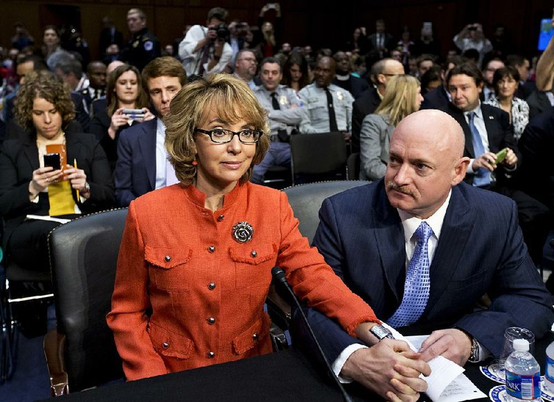 Former Congresswoman Gabrielle Giffords, who was seriously injured in the mass shooting that killed six people in Tucson, Ariz. two years ago, arrives at a Senate Judiciary Committee hearing, hand-in-hand with her husband, retired astronaut Mark Kelly, to discuss what lawmakers should do to curb gun violence in the wake of last month's shooting rampage at that killed 20 schoolchildren in Newtown, Conn., on Capitol Hill in Washington, Wednesday, Jan. 30, 2013.   (AP Photo/J. Scott Applewhite)