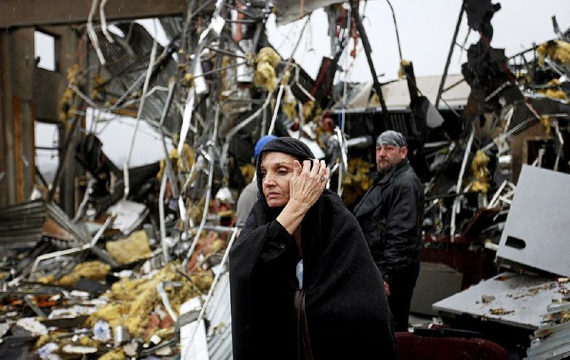 Pam Parker sifts through debris while looking for any personal belongings in the area where she was sitting at her desk when a tornado struck the Daiki plant, a metal fabrication company where she works in accounts payable, Wednesday, Jan. 30, 2013, in Adairsville, Ga. (AP Photo/David Goldman)