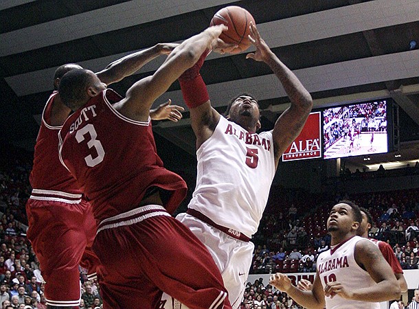 Alabama guard Trevor Lacey (5) takes a shot while Arkansas guard Rickey Scott (3) blocks during an NCAA college basketball game in Tuscaloosa, Ala., Thursday, Jan. 31, 2013. (AP Photo/Tuscaloosa News, Michelle Lepianka Carter)