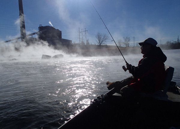 Kenny Stroud of Siloam Springs fishes at Swepco Lake Dec. 21 near the Flint Creek Power Plant. Hot water discharged from the coal-fueled plant keeps lake warm and the bass biting during winter.