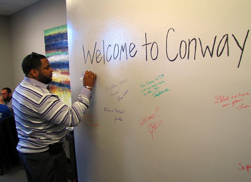 Korry Garrett signs a wall at the announcement Thursday, Jan. 31, 2013, that Internet marketing and technology firm Inuvo is moving to Conway.