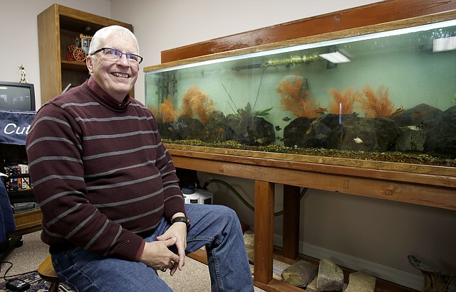 Denny Rogers sits in his favorite personal space, one of the aquarium rooms he has set up at his home near Beaver Lake.