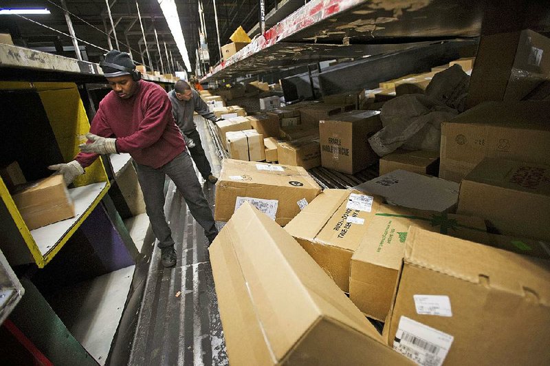United Parcel Service Inc. employees move packages at a sorting facility in San Francisco on Dec. 20. The company said Thursday that it lost $1.75 billion in the fourth quarter. 