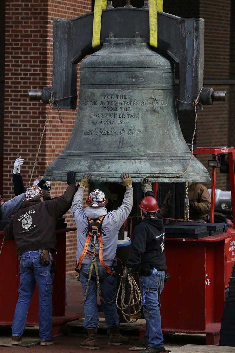 Workmen guide the Bicentennial Bell into a shipping container Thursday in Philadelphia. 