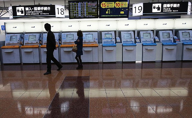 Passengers pass All Nippon Airways counters at Haneda Airport in Tokyo on Wednesday. The airline said Thursday it will bill Boeing for losses it takes related to the grounding of the 787 Dreamliner. 