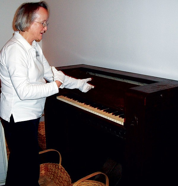 Allyn Lord, director of the Shiloh Museum in Springdale, shows off the carillon from Old Main at the University of Arkansas. The musical instrument was awaiting installation as part of “From Archaeopteryx to Zapus,” an exhibit on the history of the University of Arkansas Museum, which opens Monday. 