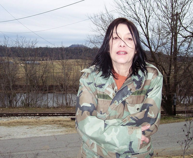 Sue McCluskey, a former  archeological technician in the Sylamore Ranger District, is shown with the Ozark National Forest and Sugarloaf Mountain in the background.